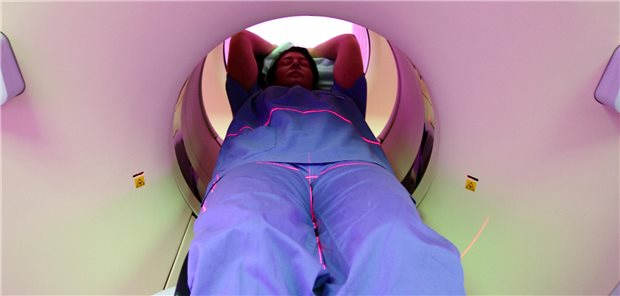 Eine Person liegt in einem Computertomograph.