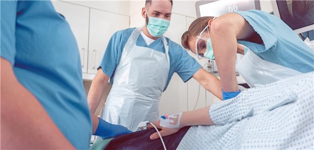 Ärzte führen eine Koloskopie durch. Die Patientin ist nur zu erahnen. 