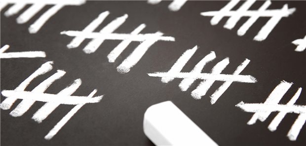 Kreide auf einer Tafel, auf welcher gezählt wird.