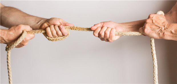 Zwei Männer machen Tauziehen gegeneinander.