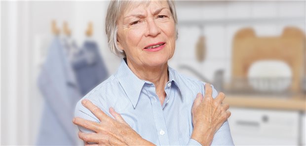 Eine ältere Frau, die an Polymyalgia rheumatica erkrankt ist, mit akuten Schmerzen in den Oberarmen und Schultern.