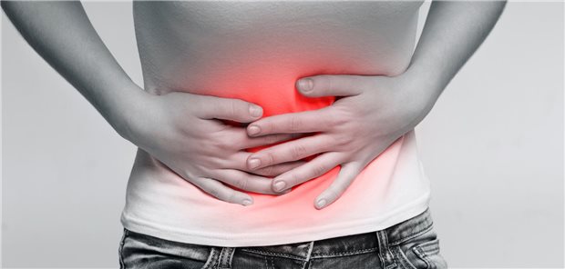 Eine Frau hält sich den schmerzenden Bauch.