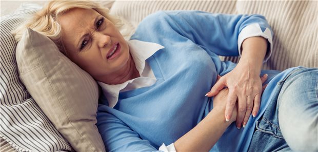 Frau hält sich den Bauch.