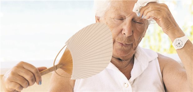 Eine ältere Dame versucht sich zu kühlen mittels Fächer und Taschentuch. 