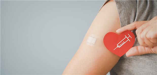Herz-Kreislauf-Erkrankungen: Prävention durch Influenzaimpfung? Herz mit aufgemalter Spritze neben Arm