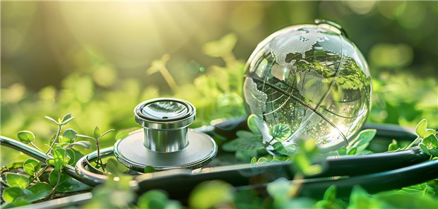 Glasglobus und Stethoskop, eingebettet in grünes Laub, als Symbol für Umweltgesundheit und ökologisch-medizinisches Bewusstsein