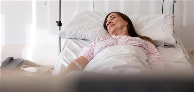 Eine Frau liegt in einem Krankenhausbett.