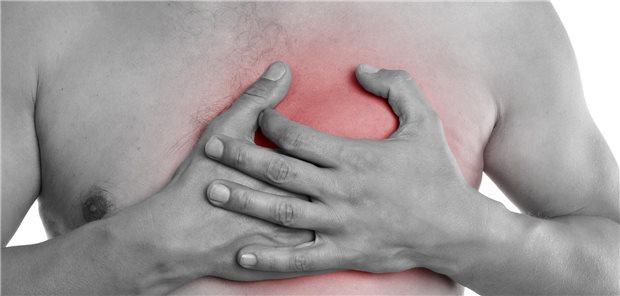 Ein junger Mann hält sich die Hände auf die Brust.