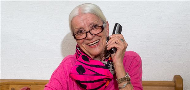 Eine Frau hält das Telefon für das "Morgenohr" hoch.