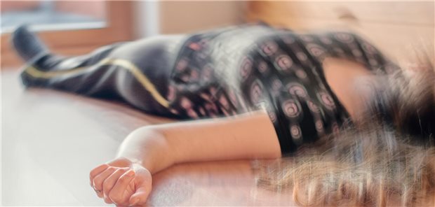 Den Anfall durchbrechen: Wie bei einem Status epilepticus vorzugehen ist Eine Frau liegt am boden. Ums ie herum ist der Raum verschwommen, als würde er sich drehen.