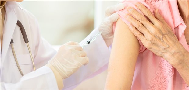 Eine Ärztin impft eine ältere Frau in den rechten Oberarm.