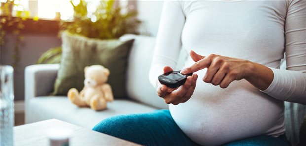 Schwangere Frau tippt auf Handy