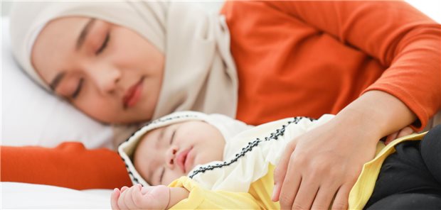 Frau mit Kopftuch und Kind im Arm