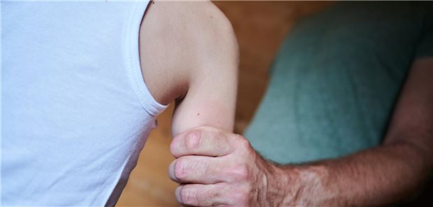 Ein Mann packt ein Kind fest am Arm.