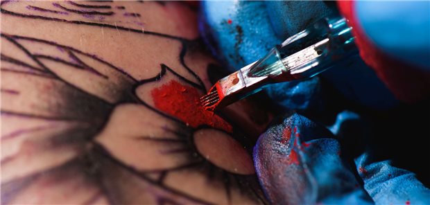 Prozess des Stechen eines Tattoos in Großaufnahme.