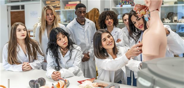 Medizinstudenten untersuchen eine Patientenpuppe.