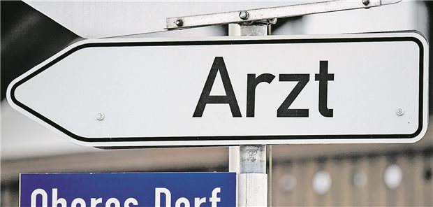 Ein Hinweisschild mit der Aufschrift "Arzt" weist den Weg zur nächsten Praxis.