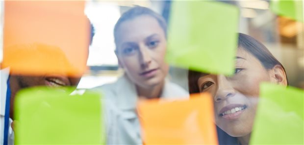 50. practica: Ein Fortbildungsformat feiert Jubiläum Ärzte vor Zetteln an einer Wand.