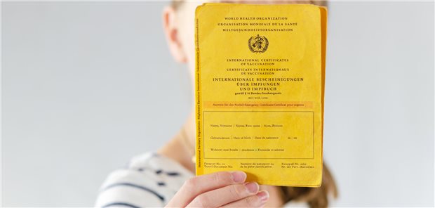 Impfen für ein gesundes Gehirn Eine junge Frau hält ihren Impfpass in die Kamera.