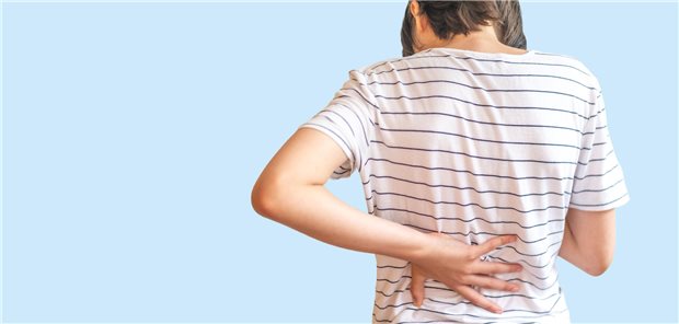 Ein Jugendlicher hält sich den Rücken.