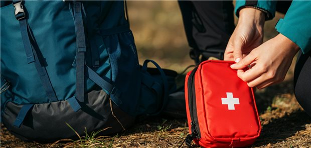 Beratungsfall Reisemedizin: Worauf es im Patientengespräch ankommt Ein Mensch öffnet einen Verbandskasten.