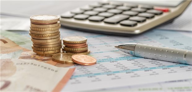 Münzen vor einem Taschenrechner