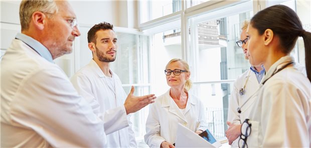 Junge und ältere Mediziner diskutieren miteinander.
