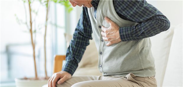 Mann greift sich an die Brust.