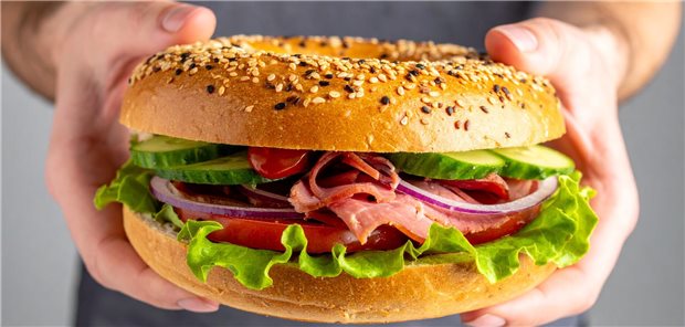 Ein Mensch hat ein Sandwich in seinen Händen.