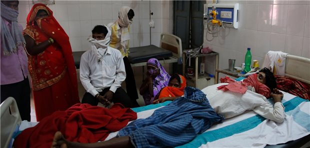 Familienangehörige stehen in einem Krankenhaus in Varanasi in Indien am Bett eines Patienten, der an Tuberkulose leidet. Die WHO sieht den Kampf gegen TB momantan in vielen Ländern gefährdet.