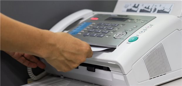 Ein Mitarbeiter empfängt ein Fax aus einem Faxgerät.