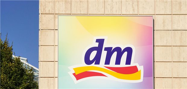 Großes Blutbild bei dm? Drogeriekette offeriert Basisdiagnostik für Selbstzahler Firmenlogo an Plattenbaufassade.