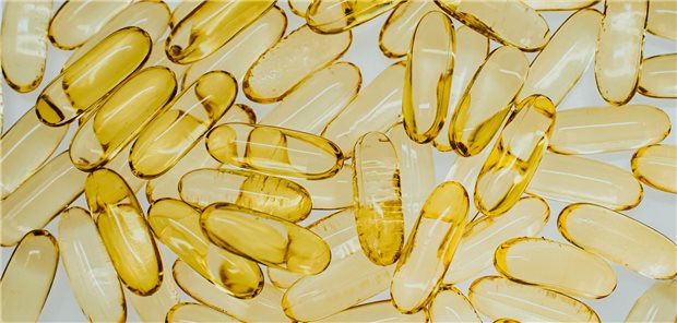 Fischölkapseln senken wohl kardiovaskuläres Risiko unter Dialyse Draufsicht auf gelbe transparente Pillen mit Fischöl auf weißem Hintergrund.