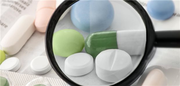 Jemand nimmt Tabletten unter die Lupe.