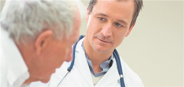 Ein Arzt berät einen älteren Patienten in der Praxis.