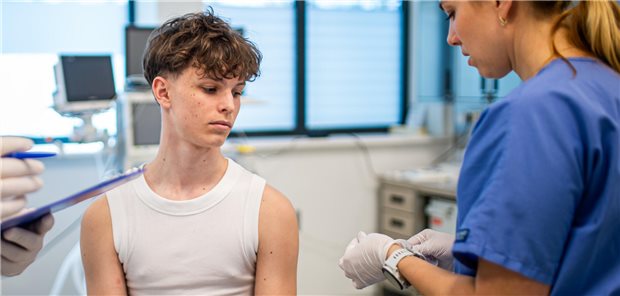 Meningokokken: Neue STIKO-Empfehlung für ältere Kinder und Jugendliche Ein junger Teenager erhält eine Memingokokken-Impfung in einer Arztpraxis.