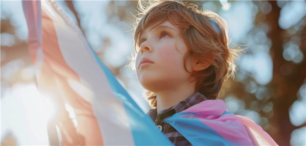 Kind mit Trans*-Fahne auf den Schultern.