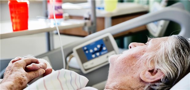 Eine Seniorin liegt in einem Krankenbett. 