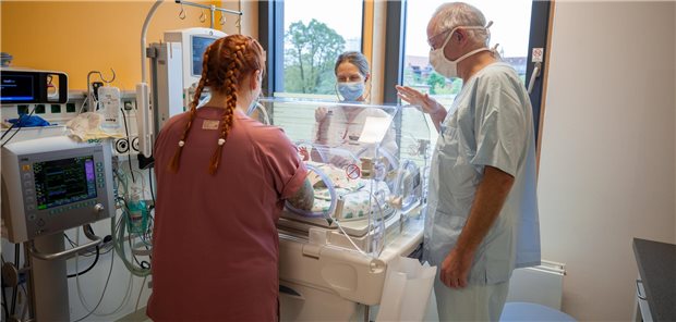 Ein Ärzteteam steht um einen Inkubator