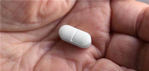 Anschreiben und E-Learning: So wurden Praxen zu rationalen Antibiotika-Verordnern Ein Mann hält eine Tablette in der Hand