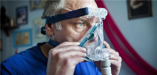 Ein Mann mit Beatmungsmaske zu Hause