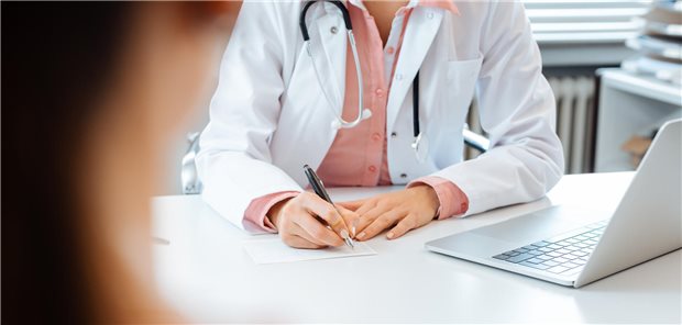 Opioide in Hausarztpraxen oft nicht leitliniengerecht eingesetzt Nahaufnahme einer Ärztin, die einer Patientin ein Rezept ausstellt.