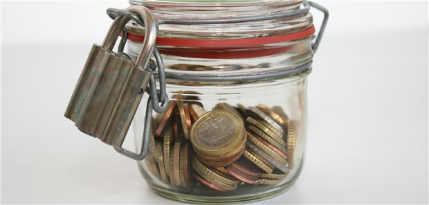 Ein Glasx mit Geld und einem Schloss davor.