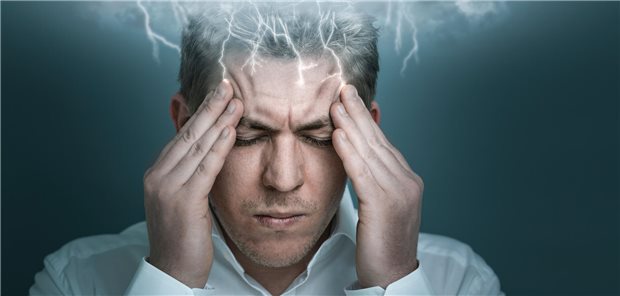 Ein Mann hält sich den Kopf.