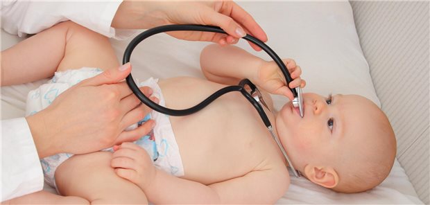 Welche Kinder holen Entwicklungsverzögerungen auf – und welche nicht? Ein Baby spielt bei der Vorsorgeuntersuchung bei der Kinderärztin mit einem Stethoskop.