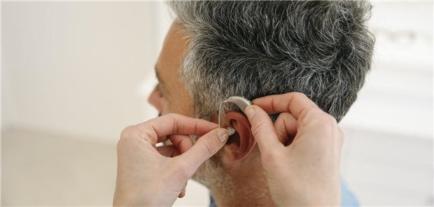 Mann erhält Hörgerät.