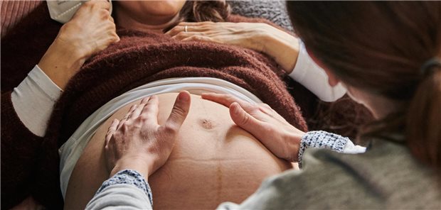 Petition: Hebammen fordern 1:1-Betreuungsgarantie für Gebärende Hebamme tastet einen BAuch ab