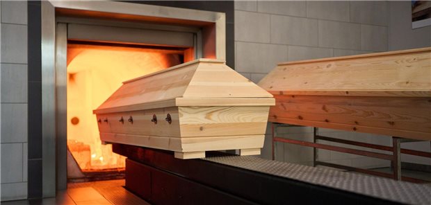 Ein Sarg im Krematorium wird ins Feuer geschoben.