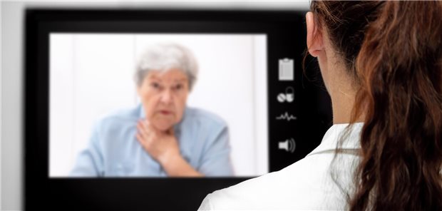 Kranke Patientin sitzt in der virtuellen Sprechstunde am Monitor.