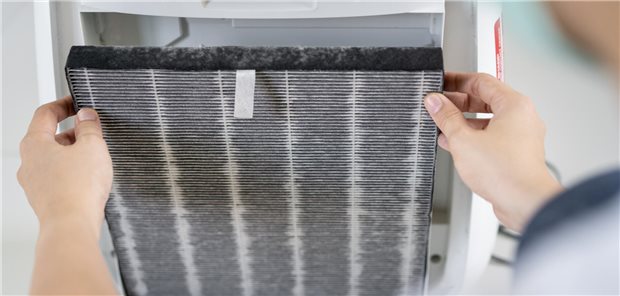 Feinstaub: Ein Partikelfilter in der Wohnung kann den Blutdruck senken Eine Frau wechselt den verschmutzten Filter des Luftreinigers nach längerem Gebrauch in einer verschmutzten Umgebung.